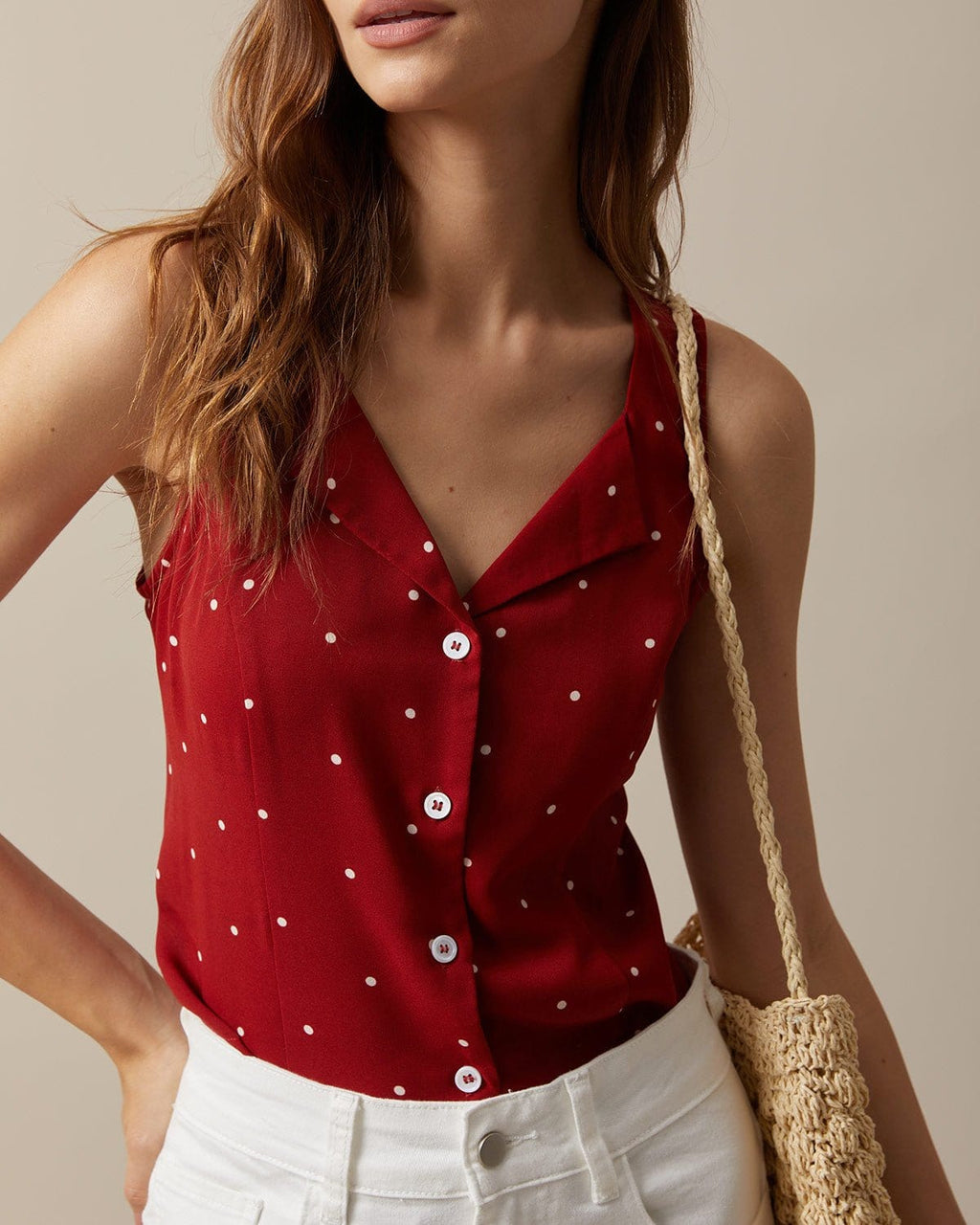 El chaleco sin mangas con cuello de pico rojo y estampado de lunares