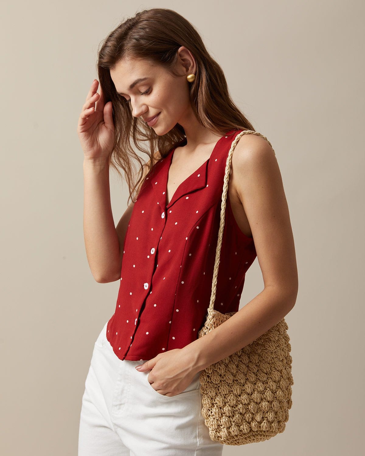 El chaleco sin mangas con cuello de pico rojo y estampado de lunares
