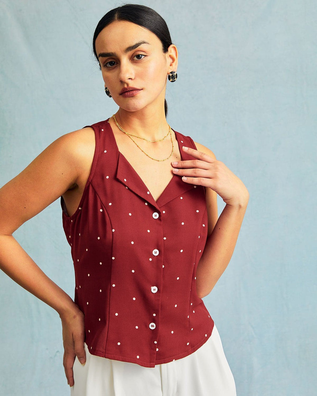 El chaleco sin mangas con cuello de pico rojo y estampado de lunares