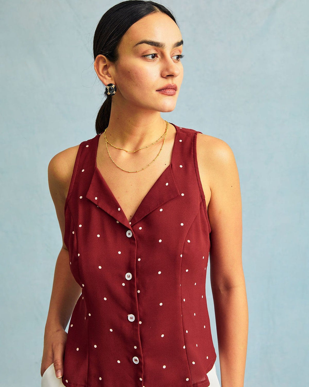 El chaleco sin mangas con cuello de pico rojo y estampado de lunares
