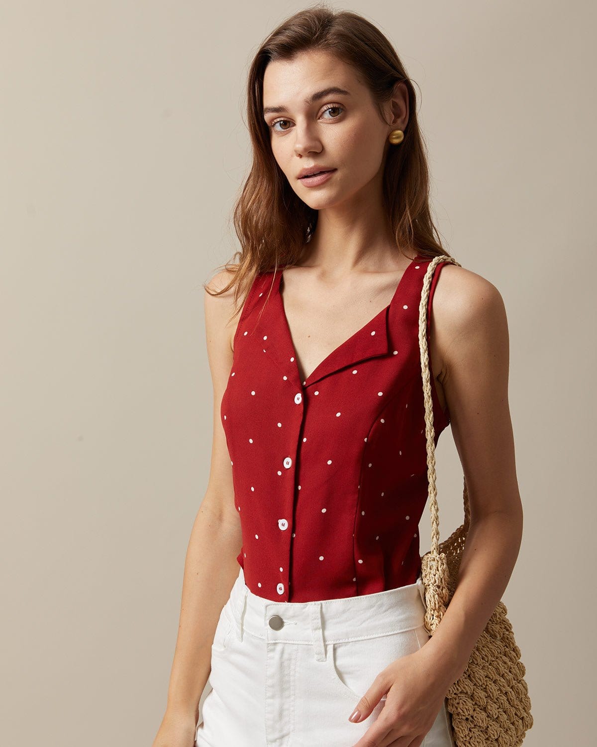 El chaleco sin mangas con cuello de pico rojo y estampado de lunares